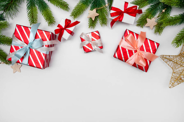 Vánoční skladba s dárkovými krabicemi, větvemi jedle, papíry Rools a dekorace na světlém pozadí. - Fotografie, Obrázek