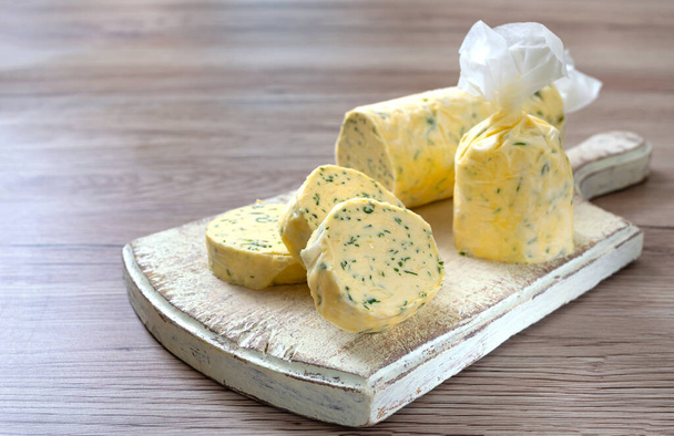 Butter with dill, parsley in the form of a roll, chunks for easy use. Herbal butter on a cutting board - Photo, Image