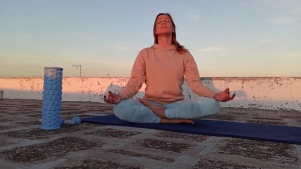 Erwachsene sportliche Frau meditiert auf dem Dach ihres Hauses, Zen-Yoga-Meditationspraxis in Outdoos - Filmmaterial, Video
