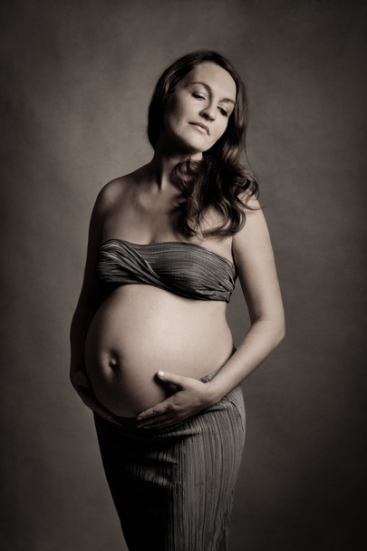 Portrait of beautiful pregnant woman in studio - 写真・画像