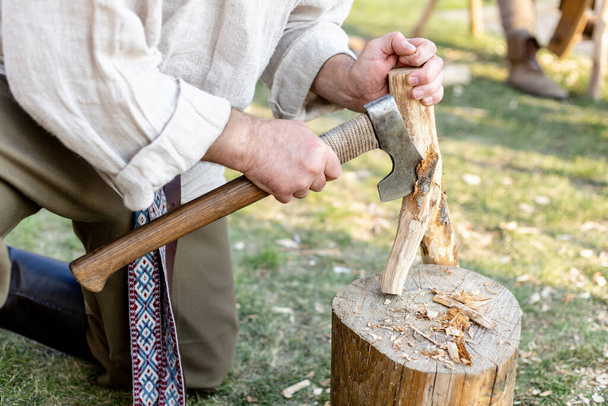 a man chopping a branch with an ax - Foto, imagen