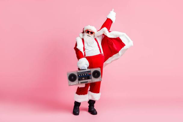 X-mas christmas disco party concept. Full length photo cool funky overweight santa claus ready listen boom box retro rhythm sound wear sunglass cap pants isolated pastel color background - Фото, зображення
