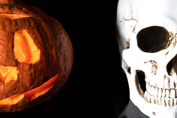halloween 2020 and coronavirus. Happy halloween Carving. Halloween pumpkin head lantern on black background, with  human skull.  idea for halloween                      - Photo, Image