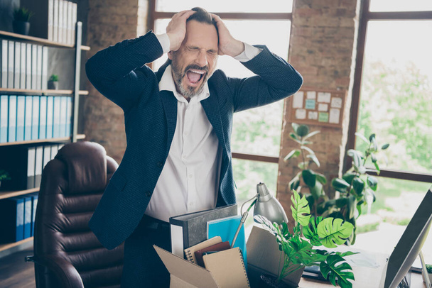 Photo of tired fired crying worker mature guy fail businessman suffer terrible head ache lost job pack belongings box stressed scream desperate leave office financial crash desktop indoors - Fotó, kép