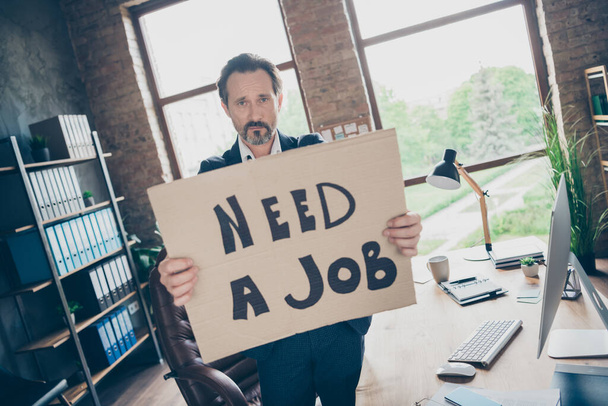 Not boss anymore. Photo of moody despair sad laid off dismissed worker mature guy hold placard poster search new job last work day workplace fired bad mood modern office indoors - Fotografie, Obrázek