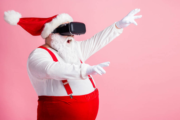 Profile side view portrait of his he bearded fat overweight Santa wear vr helmet gadget device equipment enjoying watching realistic experience air blow wind isolated pink pastel color background - Valokuva, kuva