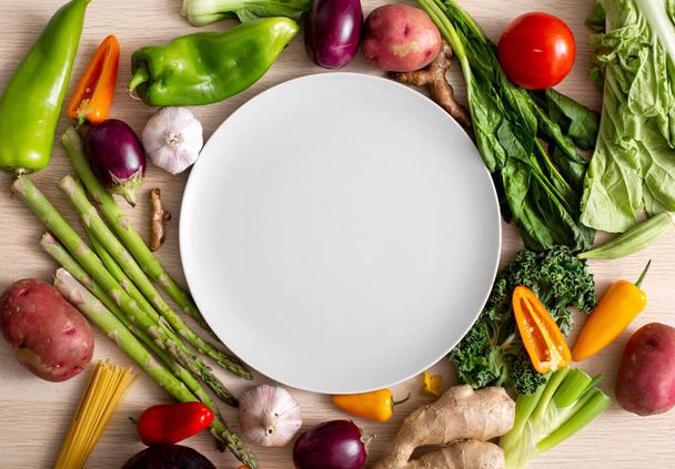 Assortment of vegetables with empty plate, top view - Photo, Image