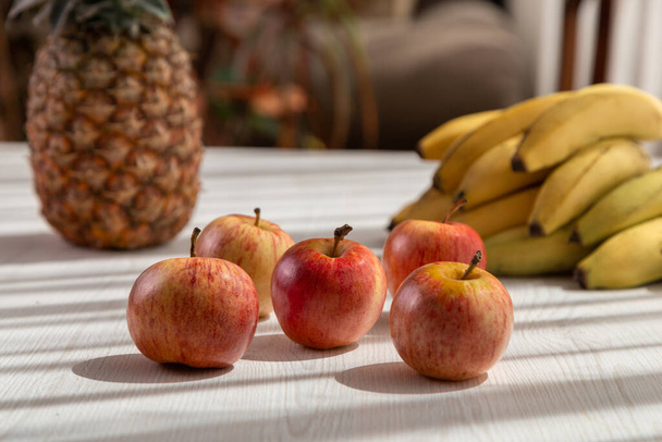 köstliche frische Früchte auf weißem Hintergrund, Schatten und Sonne, Ananas, Äpfel und Bananen, gesunder Lebensstil, Studiodesign - Foto, Bild