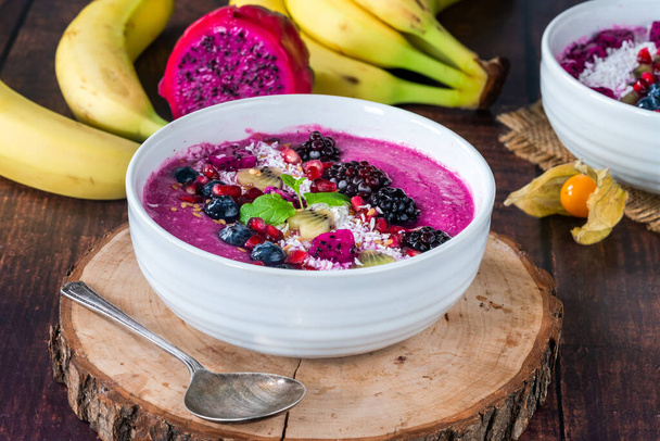 Pink pitaya smoothie bowls with fruit, coconut flakes and linseed - healthy breakfast idea. - Photo, image