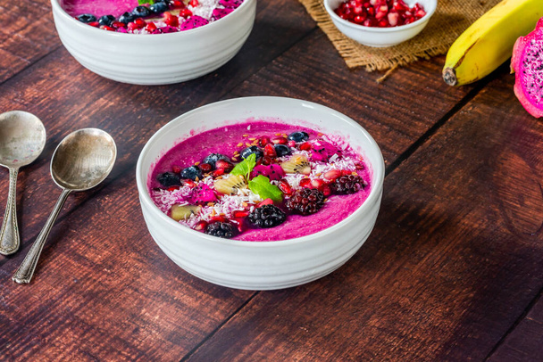 Pink pitaya smoothie bowls with fruit, coconut flakes and linseed - healthy breakfast idea. - Valokuva, kuva