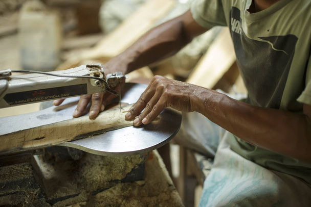 Situbondo Ανατολική Ιάβα Ινδονησία, 13-10-2020. Χέρια ξυλογλυπτική ενώ εργάζονται με τα εργαλεία στο Kampung Blekok. - Φωτογραφία, εικόνα