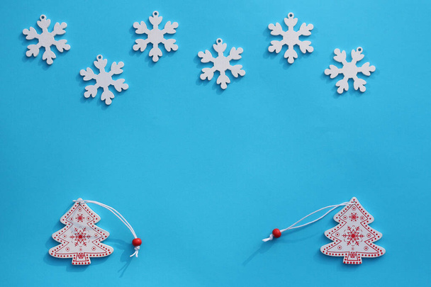 Composição criativa de Natal. Brinquedos de Natal de madeira em um fundo pastel azul. Delicado maquete de cartão de saudação. Minimalismo. Deitado. Espaço de cópia - Foto, Imagem