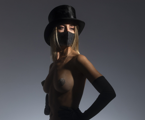 Mujer joven con máscara facial brillante y sombrero de copa - Foto, imagen