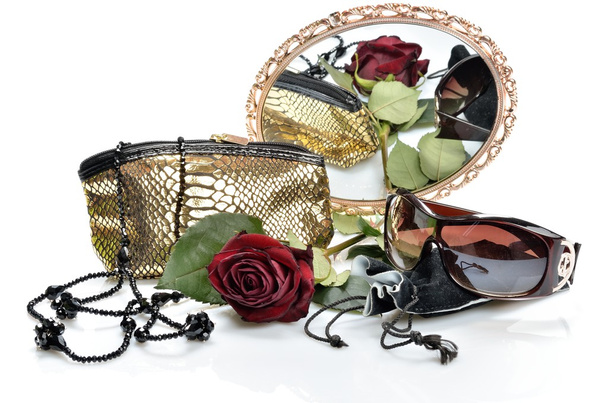 Women's handbag, accessories, sunglasses and a red rose are seen in the mirror - Foto, Bild
