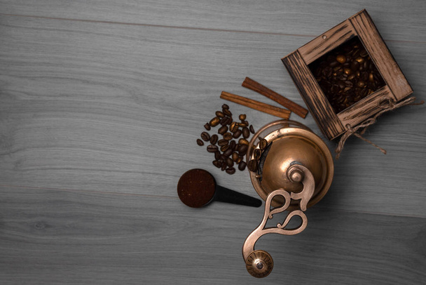Granos de café en caja de madera, palitos de canela, café molido en cuchara, molino de café vintage   - Foto, Imagen