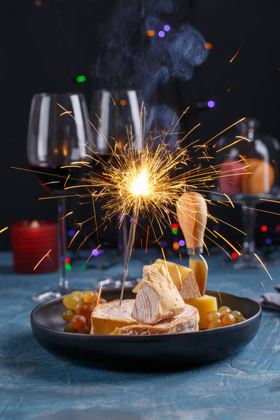 休日のテーブルの上にチーズプレート。チーズとワイン、お祝いの飾り. - 写真・画像
