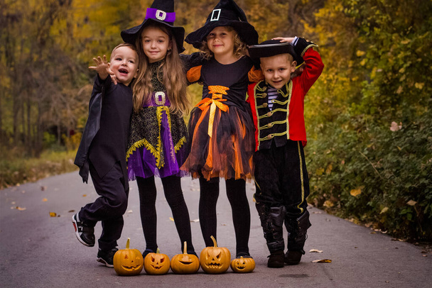 Crianças de Halloween em trajes ao ar livre. Feliz cartão do Dia das Bruxas. Férias de outono divertido. Engraçado crianças partido expressão. Decoração de abóbora queda - Foto, Imagem