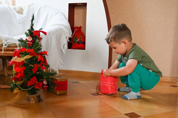 Child in the morning near the Christmas tree. High quality photo - Fotoğraf, Görsel