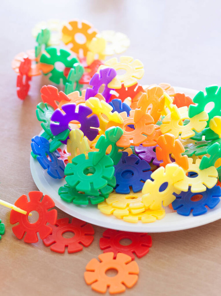 Muovihiutaleet lohkot lautasella. Ohjeellinen lelu, joka edistää alueellista hhinkkausta ja hienomotoriikkaa - Valokuva, kuva