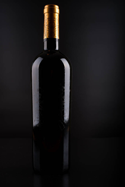 wine bottle with black silhouette background - Foto, imagen