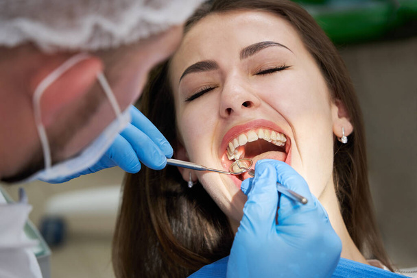 Mujer revisando sus dientes en el consultorio del dentista - Foto, imagen