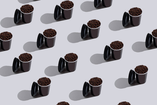 σχέδιο μαύρο χαρτί μιας χρήσης φλιτζάνια με κόκκους καφέ σε λευκό φόντο, έννοια - Φωτογραφία, εικόνα