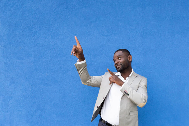 the African American shows hands up on blue background - Photo, Image