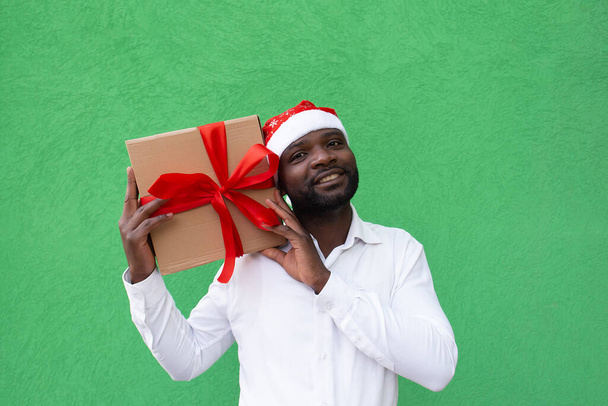 o afro-americano no gorro de um Ano Novo com um presente - Foto, Imagem