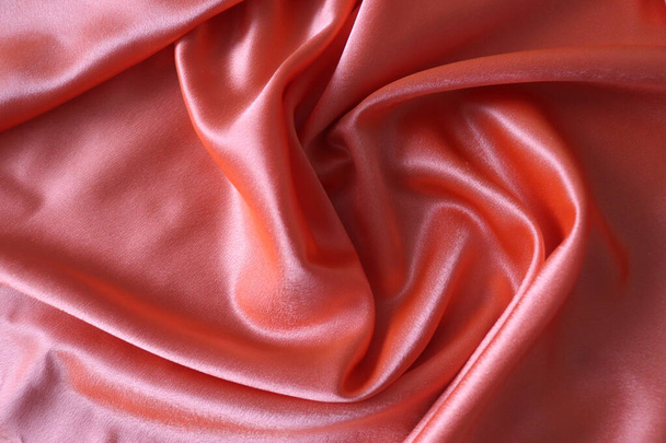 Smooth elegant coral silk or satin fabric. Draped luxury cloth texture for design. Close-up. - Photo, Image