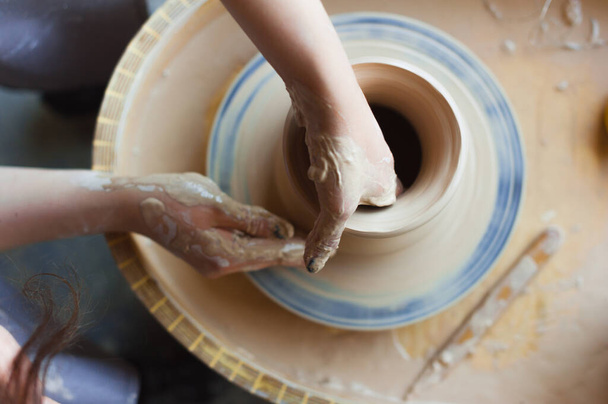 Mains féminines dans un atelier de poterie gros plan, vue du dessus. - Photo, image