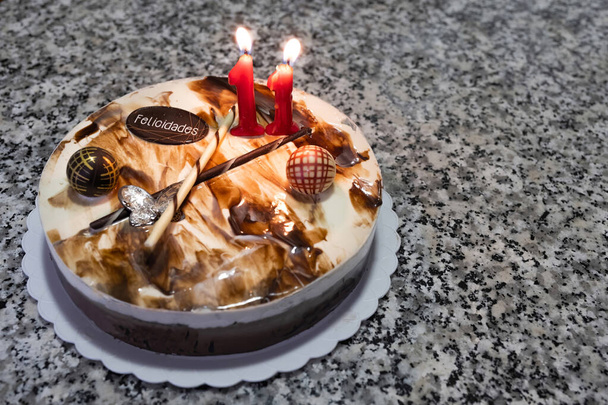 Три шоколадні пироги з свічкою на день народження з номером 11 та шоколадним баром з текстом з днем народження іспанською мовою (felic...), торт на день народження на мармуровому столі
 - Фото, зображення