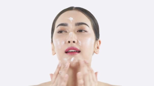 Beauty concept. Young Asian woman applying cream on her face. 4k Resolution. - Imágenes, Vídeo