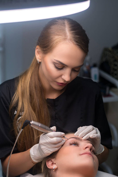 Maquillage permanent des sourcils. Cosmetologue appliquant le tatouage des sourcils.  - Photo, image