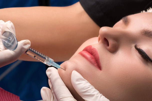 Chin lipofilling. Woman getting cosmetic injection of botulinum - Fotó, kép