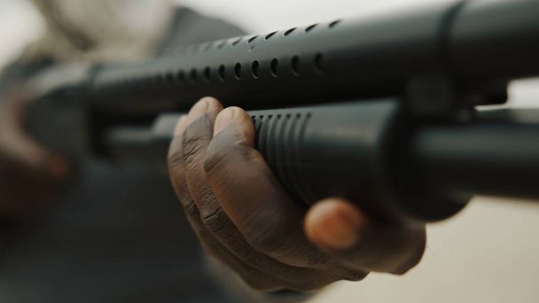 Az afro-amerikai férfi újratölt egy vadászpuskát. Közelről.. - Fotó, kép