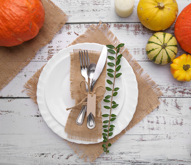 autumn composition with cutlery, candle plate and pumpkins . - Foto, afbeelding