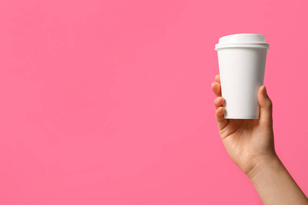 Woman holding takeaway paper coffee cup on pink background, closeup. Space for text - Foto, Imagen