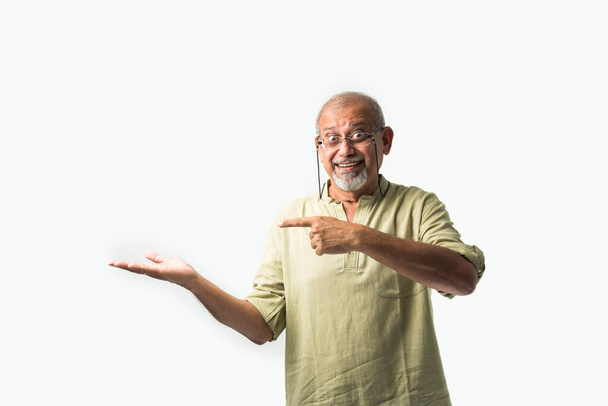 ásia indiana sênior ou idade homem apresentando vazio espaço de pé isolado contra branco fundo - Foto, Imagem