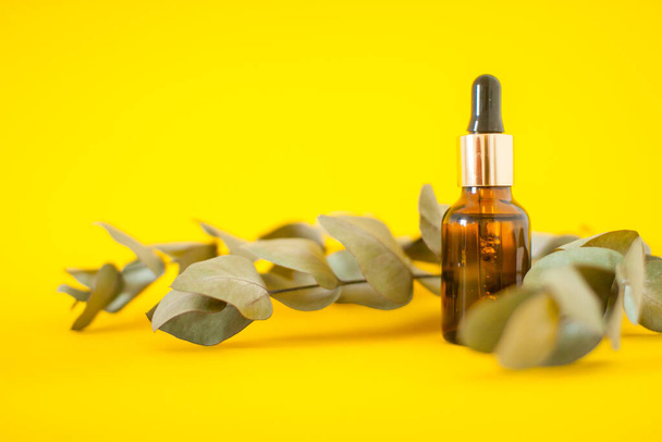 Cosmetic bottles with serum on a bright yellow background. Cosmetology and beauty concept. - Foto, immagini