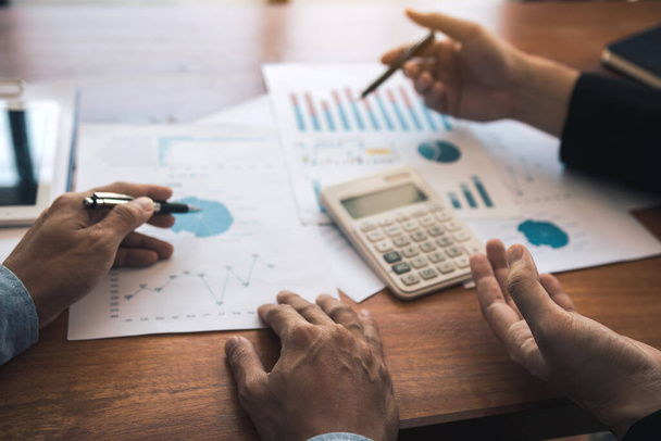 Két üzleti partneri munkatárs elemzési stratégia pénzügyi tervezési grafikon és vállalati költségvetés megvitatásával egy költségvetési ülés során az irodateremben. - Fotó, kép