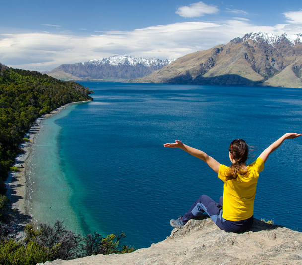 A closeup shot of a lady enjoying the view of a lake and mountains from the Bobs Cove Track, Queenstown, New Zealand - Foto, Imagem
