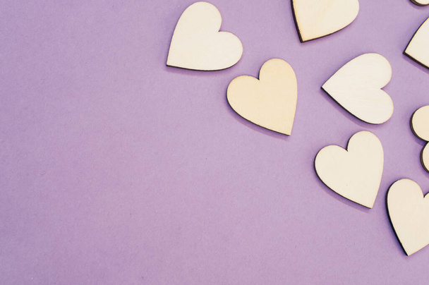 A top view of the wooden shaped hearts on the purple surface - space for text - Фото, зображення