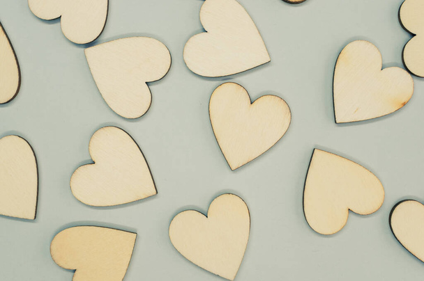 A top view of the wooden shaped hearts on the gray surface - Photo, image