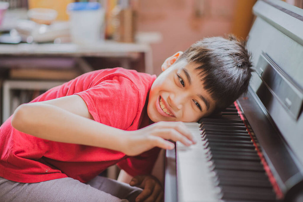 Petit garçon apprenant à pratiquer le piano tablette numérique en ligne
 - Photo, image