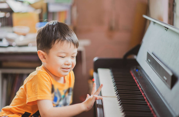 Pieni poika oppiminen harjoitellaan piano verkossa digitaalinen tabletti
 - Valokuva, kuva