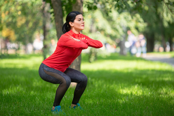 Donna che fa esercizi per le gambe nel parco cittadino. - Foto, immagini
