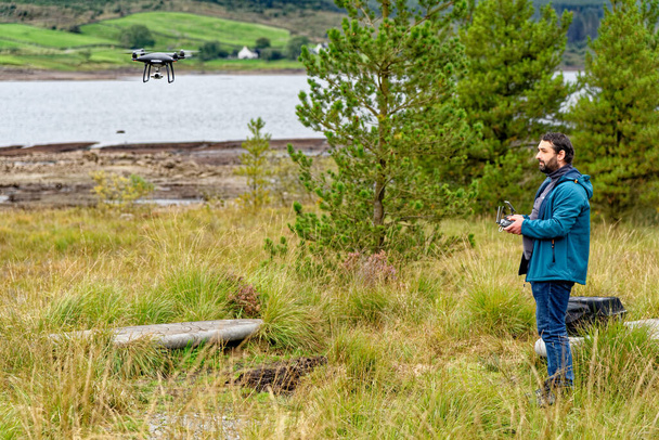 Drone pilot after take off with a DJI drone in Galloway Forest Park, Scotland - united Kingdom - 15th of September 2020 - Photo, Image
