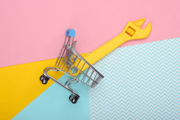 Mini bevásárlókocsi egy játék kulcs színes pasztell háttér. Első látásra. Minimalizmus - Fotó, kép