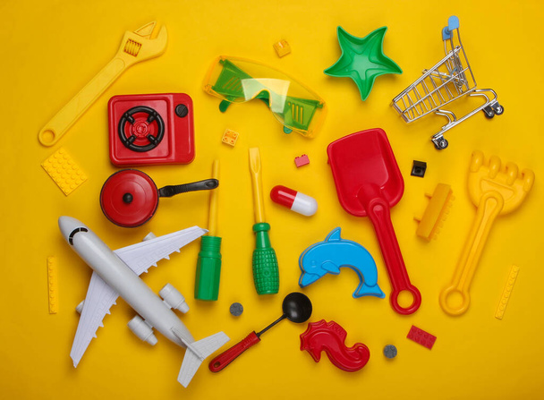 Beaucoup de jouets pour enfants sur fond jaune. Concept d'enfance. Vue du dessus - Photo, image