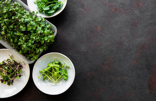Assortment of micro greens at black background, copy space, top view. Healthy lifestyle - Photo, Image
